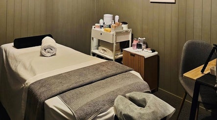 Elysian Beauty massage room in Winton, Southland Region, NZ. Cozy bed with essentials for relaxation.