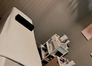 Calm treatment room at Elysian Beauty, Winton, Southland Region, NZ with a massage table and beauty products.
