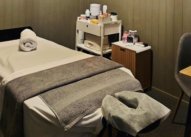 Massage room at Elysian Beauty, Winton, Southland Region, NZ, featuring a tranquil setting with a prepared table.
