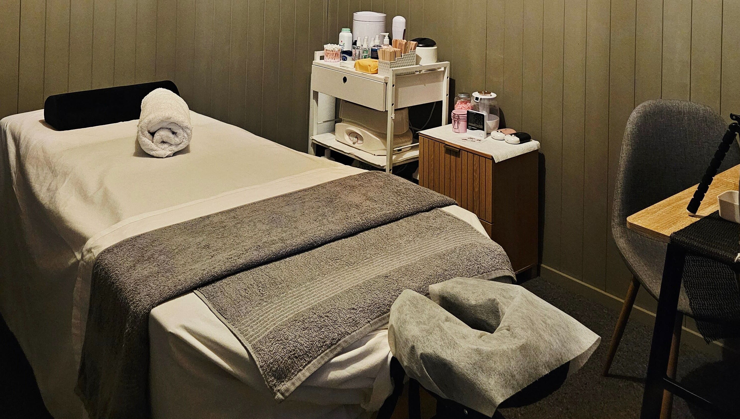 Relaxing treatment room at Elysian Beauty, Winton, Southland Region, NZ, featuring a massage table and cozy decor.