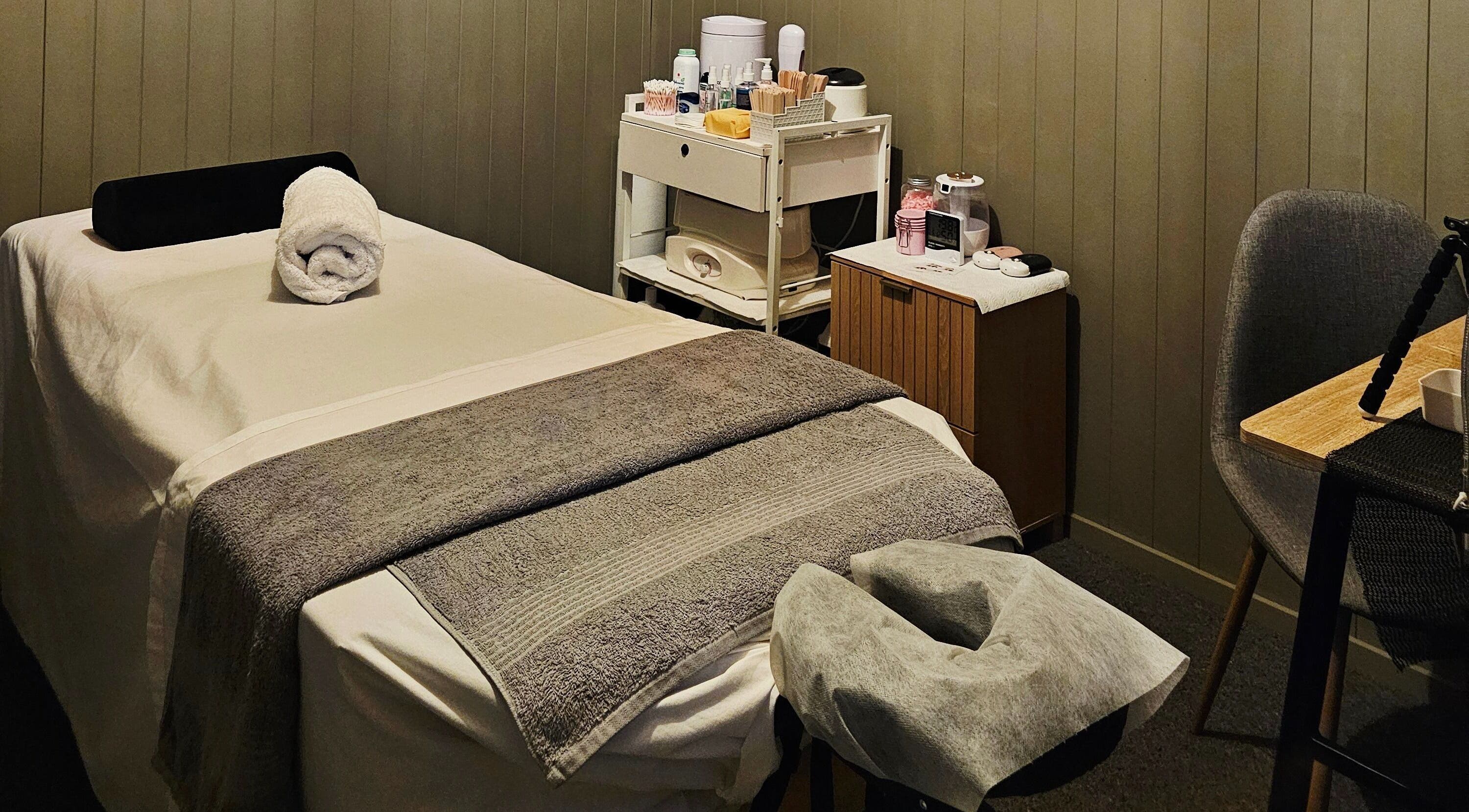 Relaxing treatment room at Elysian Beauty, Winton, Southland Region, NZ, featuring a massage table and cozy decor.