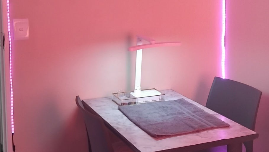 Cozy manicure station at The Polish Persona, Cape Town, Western Cape, ZA, illuminated with soft pink lighting.