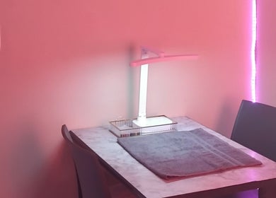 Cozy manicure station at The Polish Persona, Cape Town, Western Cape, ZA, illuminated with soft pink lighting.