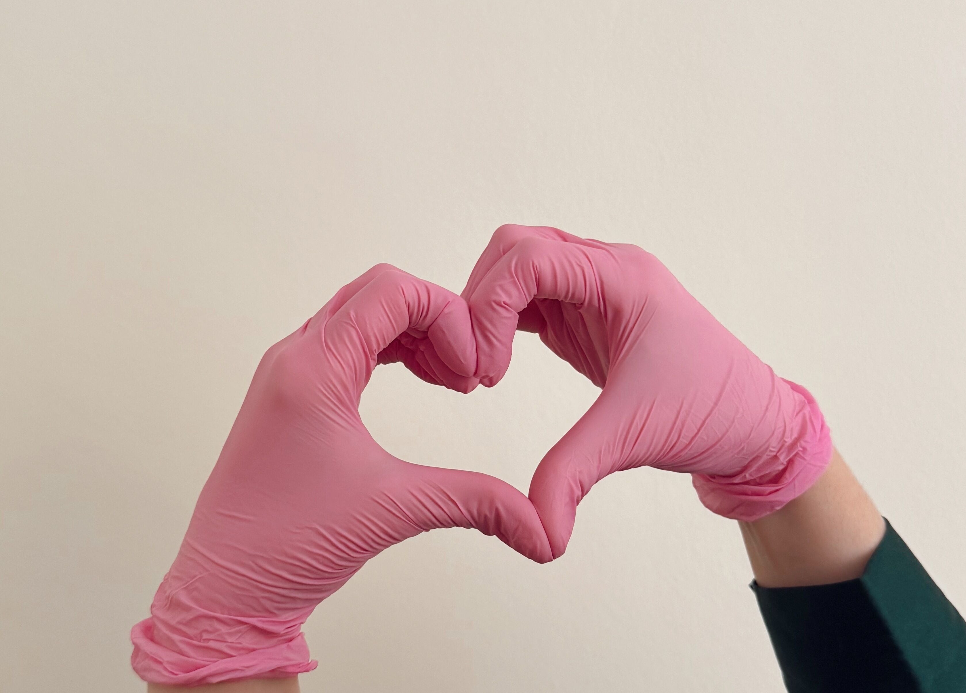 Pink gloved hands form a heart at Aesthetics by Giulia, Dublin, County Dublin, IE.