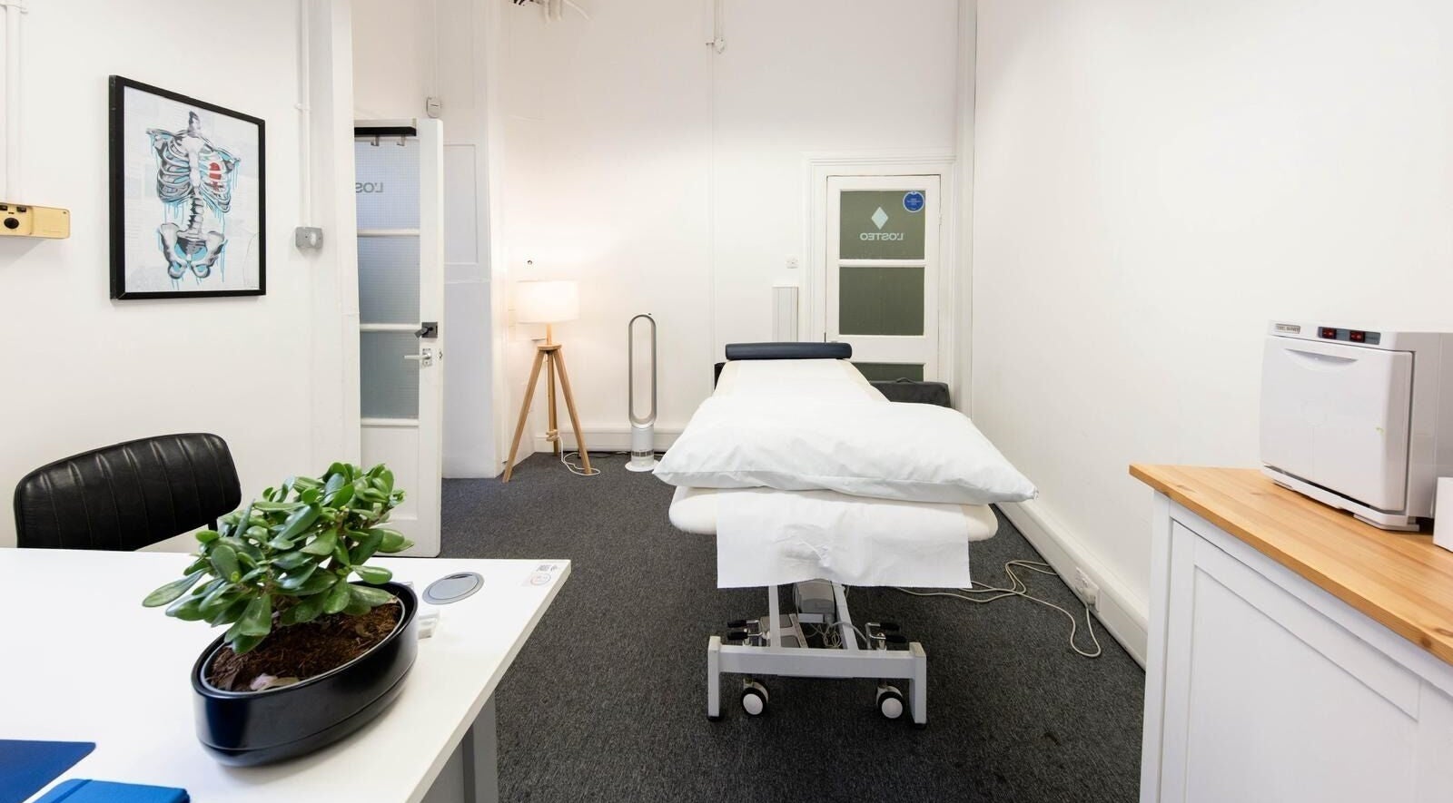 Therapy room at The Flow Clinic in London, England, GB with a massage table, modern décor, and calming ambiance.