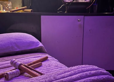 Relaxing massage setup at Sapphire Soul Alchemy, GB with bamboo sticks on a plush bed.