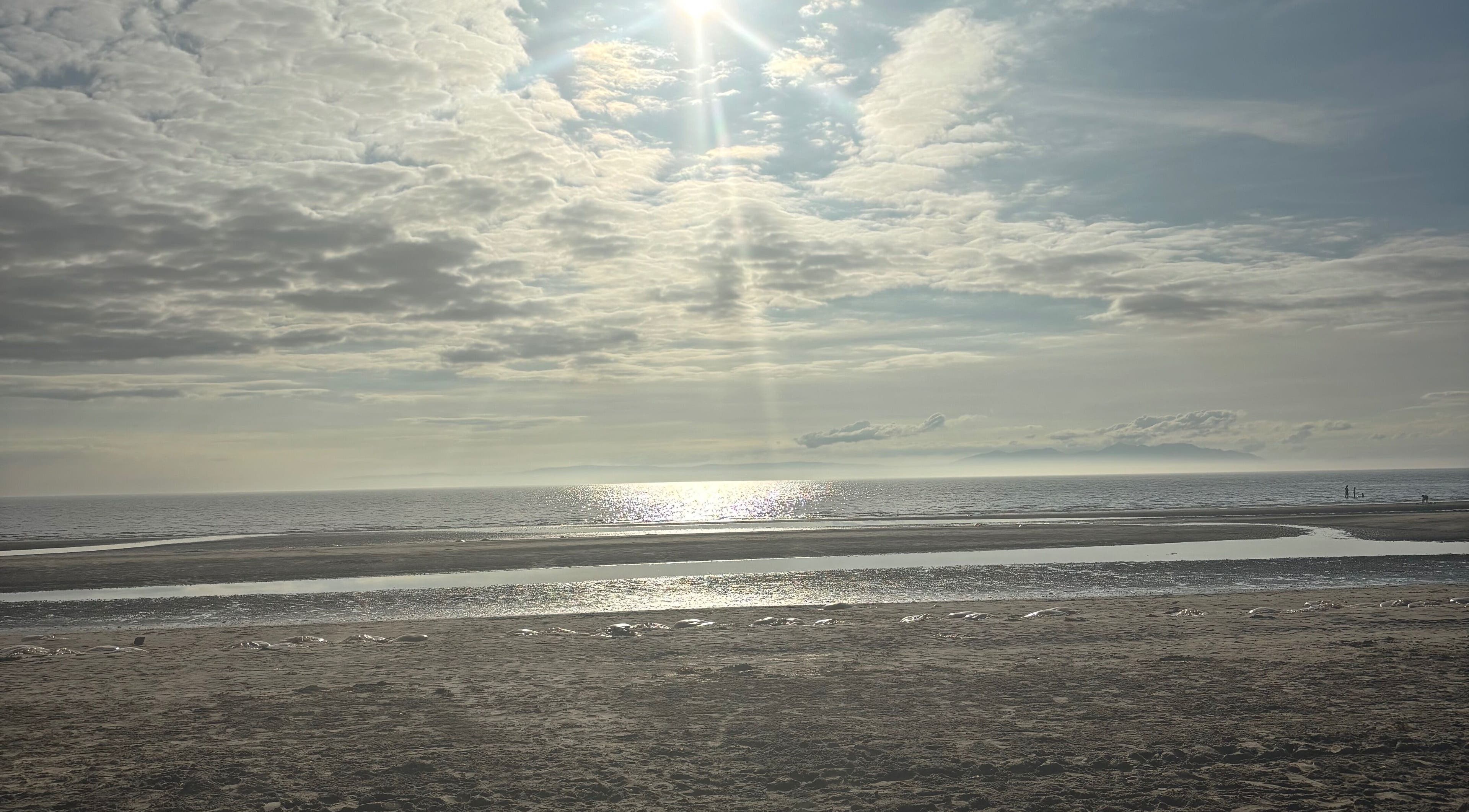 Tranquil seascape near Sapphire Soul Alchemy, GB, with sunlit waves and vast sky.