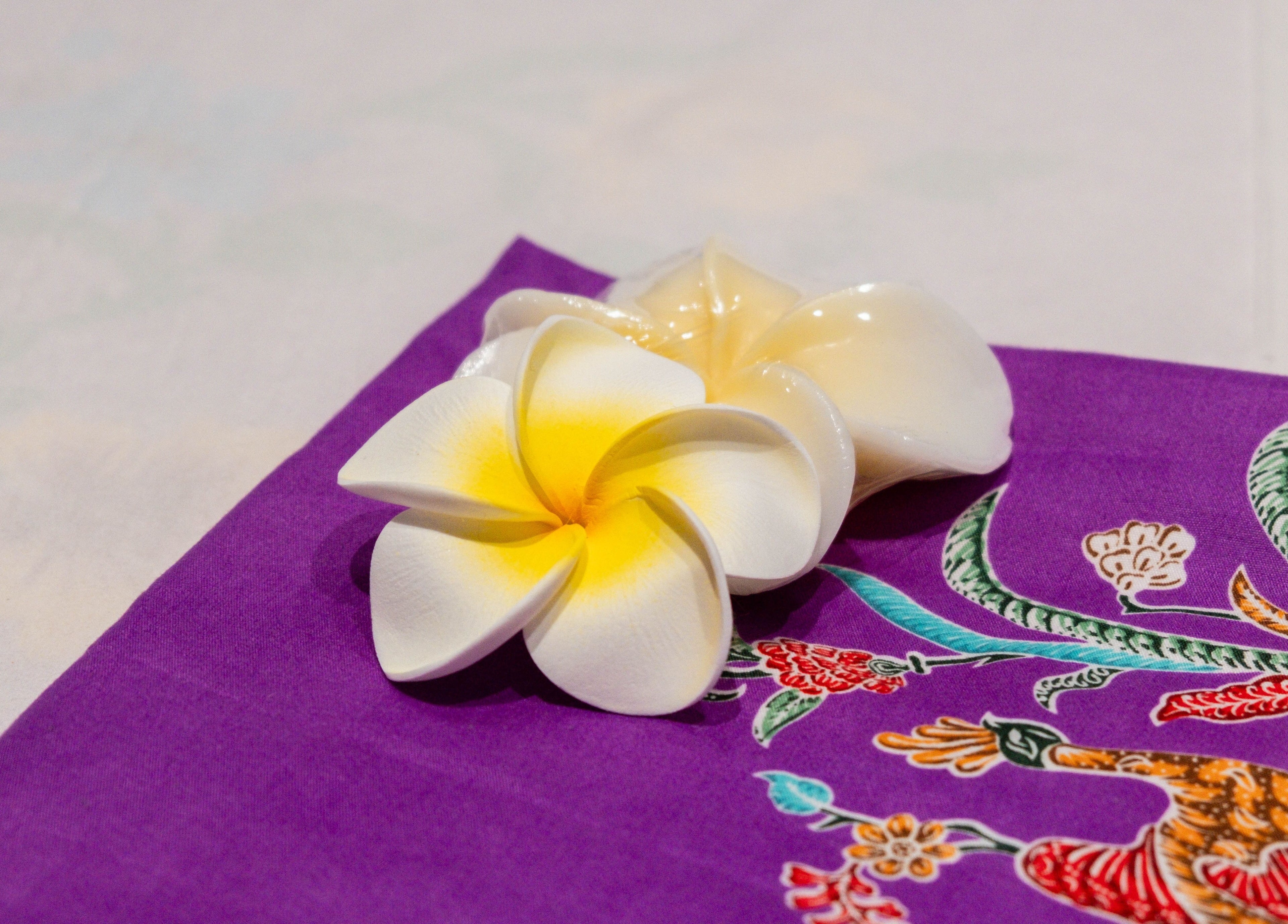 Frangipani flower on colorful fabric at Paanthong Thai Spa, London, England, GB.
