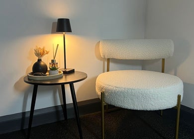 Chic waiting area at Aesthetics By Dr Suchira, Windsor, England, GB, with soft chair and warm lighting.