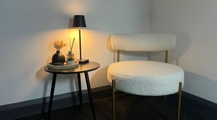 Chic waiting area at Aesthetics By Dr Suchira, Windsor, England, GB, with soft chair and warm lighting.