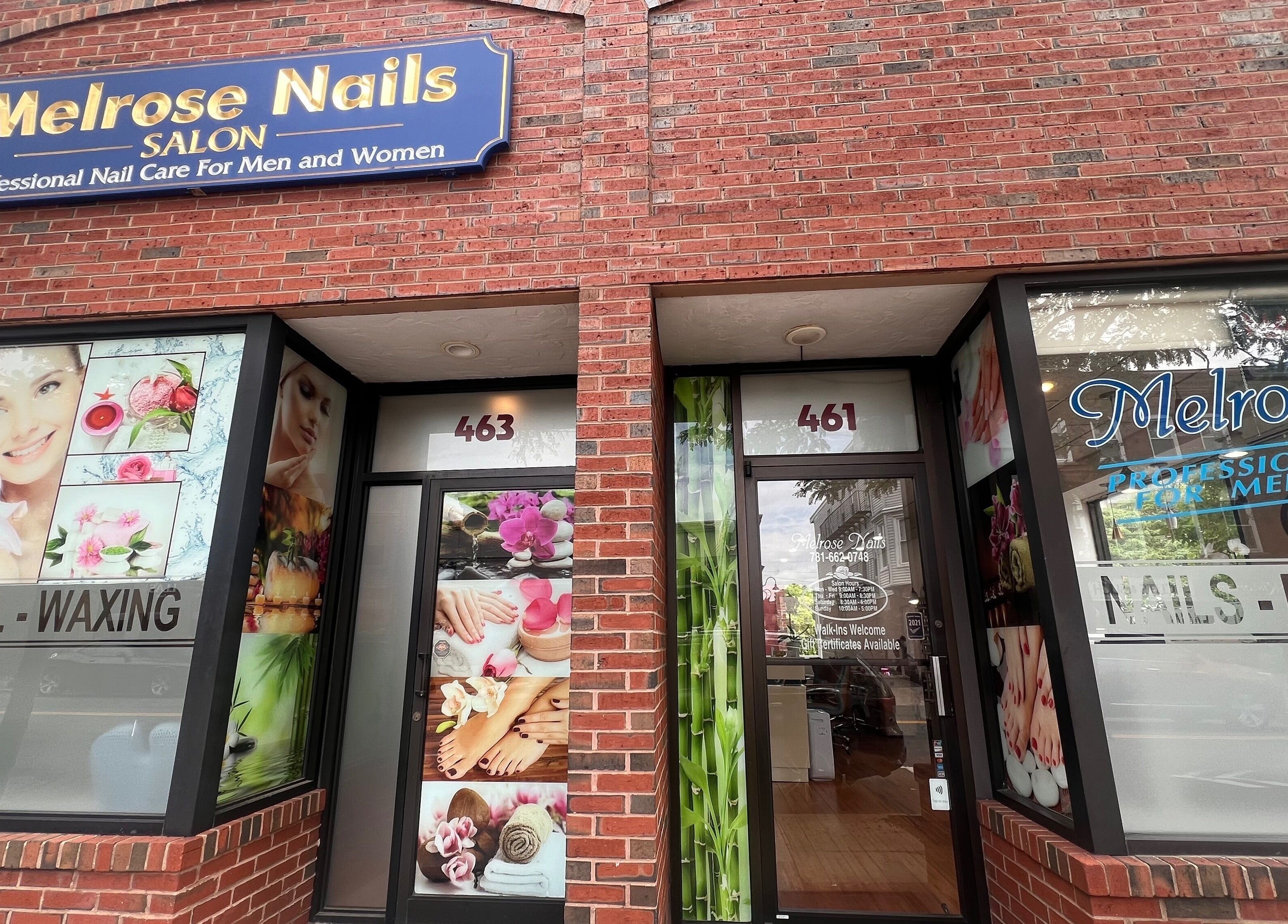 Front view of Melrose Nails in Melrose, Massachusetts, US, showcasing vibrant beauty images on a brick facade.