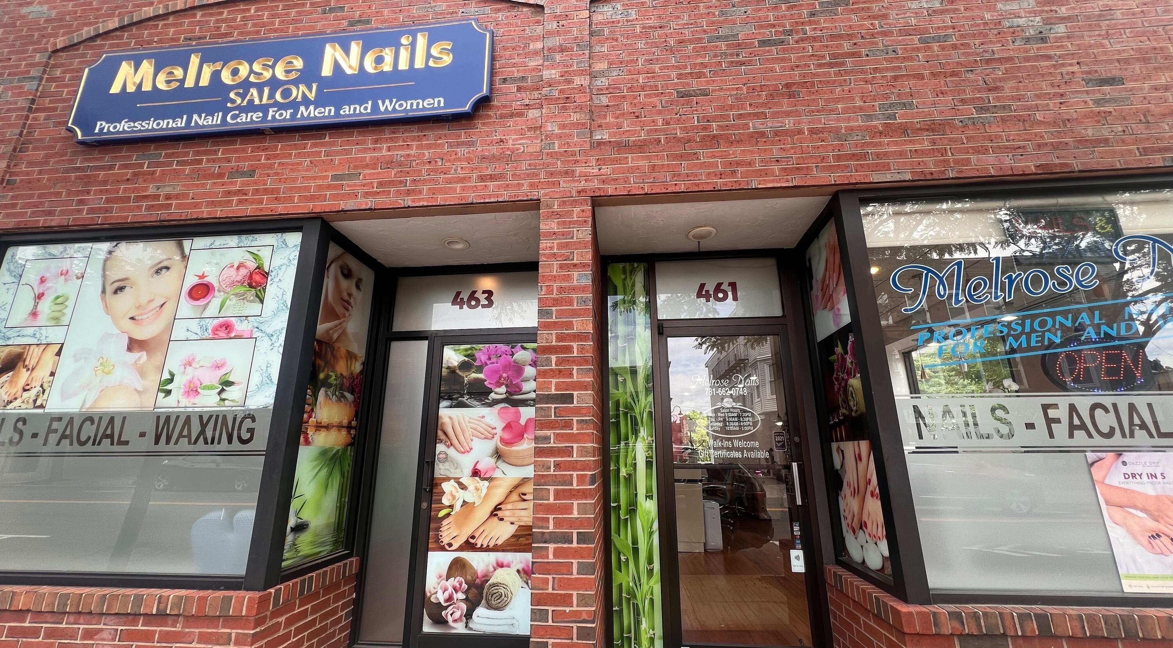 Front view of Melrose Nails in Melrose, Massachusetts, US, showcasing vibrant beauty images on a brick facade.