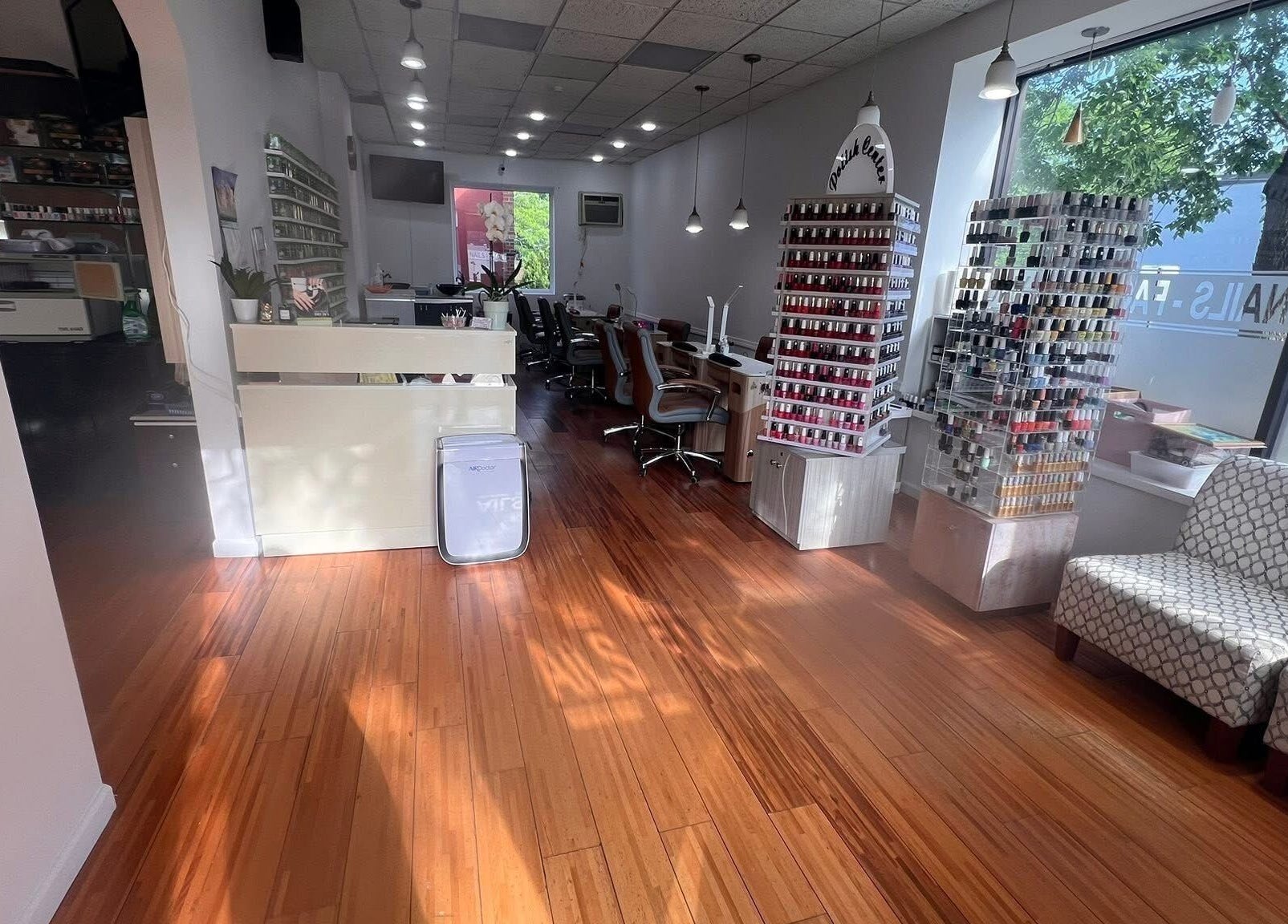 Interior of Melrose Nails in Melrose, Massachusetts, US featuring polish displays and seating area.