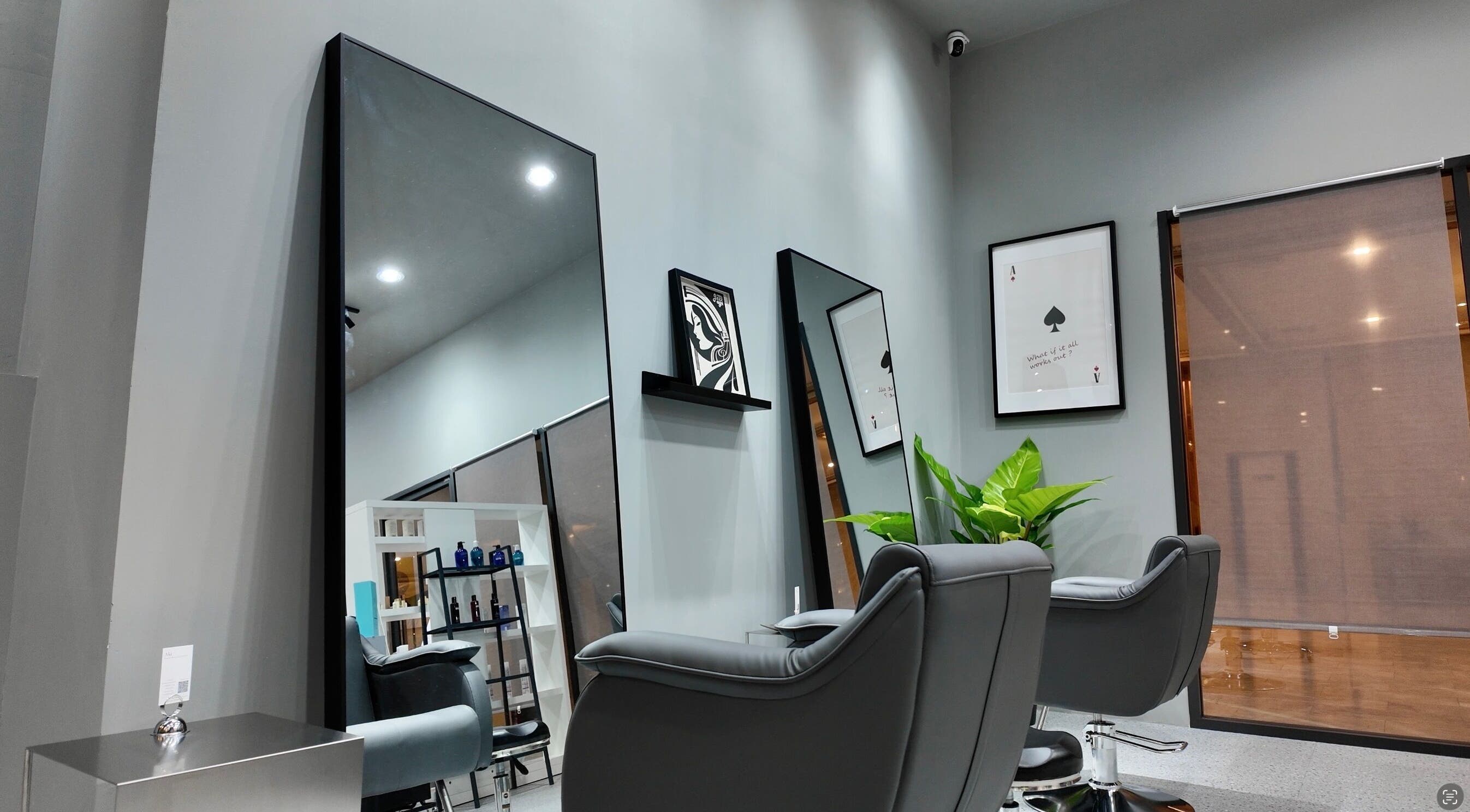 Modern interior of Ciel Japanese Hair Studio, Khlong Toei, Bangkok, featuring sleek salon chairs and mirrors.