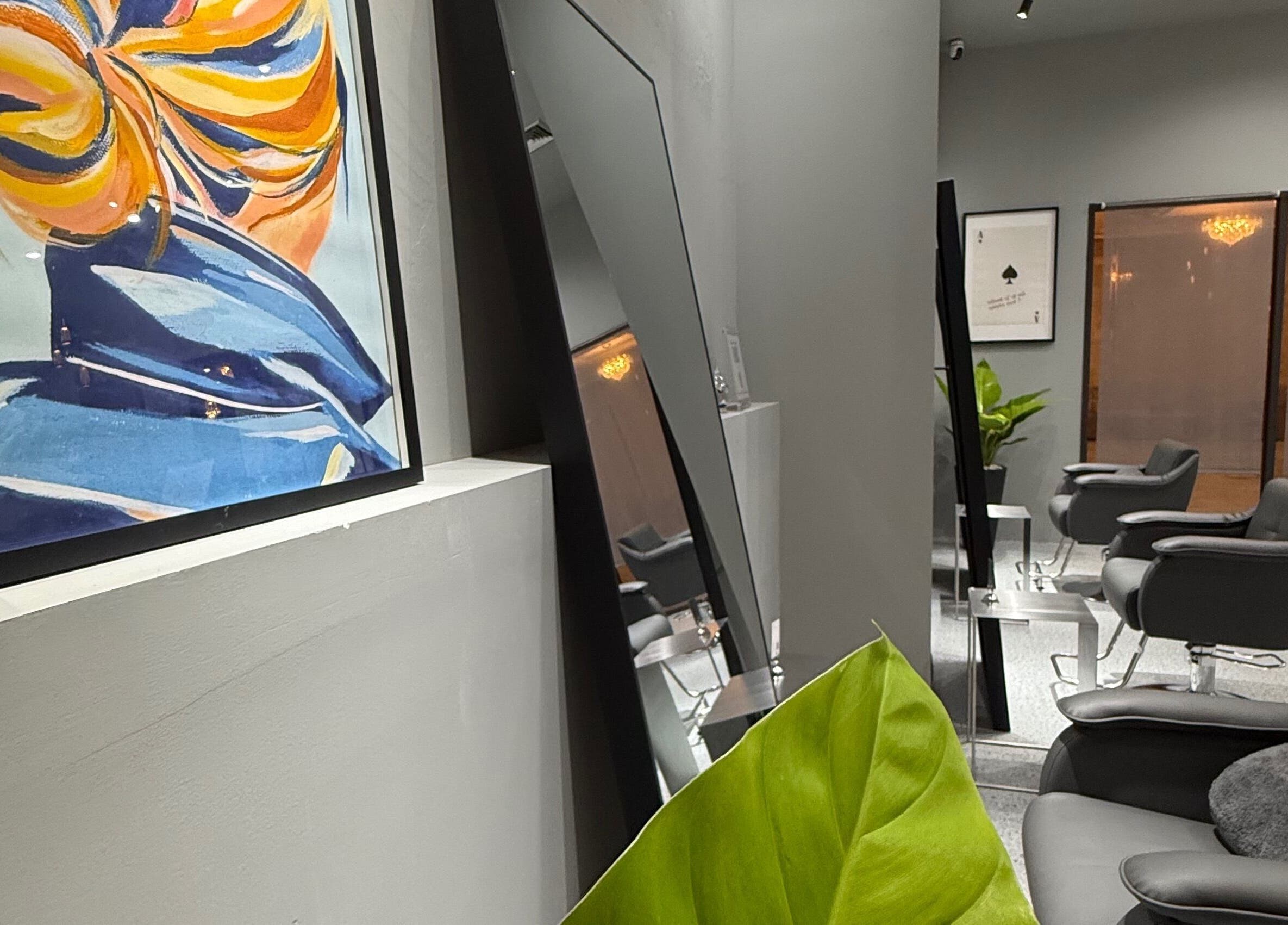 Stylish interior at Ciel Japanese Hair Studio, Khlong Toei, Bangkok with chic chairs and vibrant artwork.