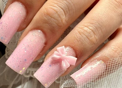 Unghii roz cu strălucire și fundiță la ExB Nails, Knaphill, England, GB.