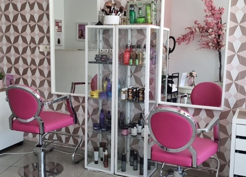 Interior do salão Gabrielas Cabeleireiro e Estética em Loures, Lisboa, PT, com cadeiras rosas e espelho.