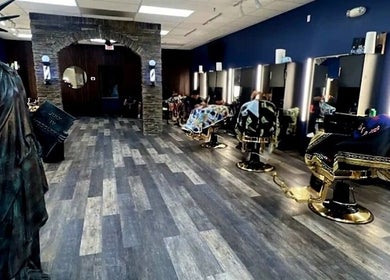 Interior of Quinnbarber in Tulsa, Oklahoma, US, featuring a Statue of Liberty replica and modern barber chairs.