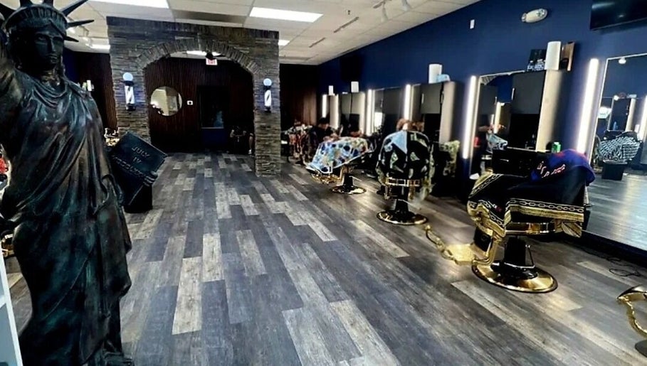 Modern interior of Quinnbarber in Tulsa, Oklahoma, US, featuring stylish barber chairs and Statue of Liberty decor.