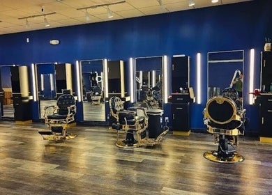 Interior of Quinnbarber in Tulsa, Oklahoma, US showcasing stylish barber chairs and illuminated mirrors.