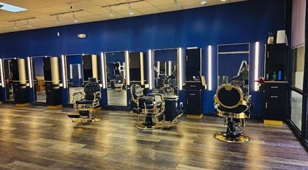 Interior of Quinnbarber in Tulsa, Oklahoma, US showcasing stylish barber chairs and illuminated mirrors.