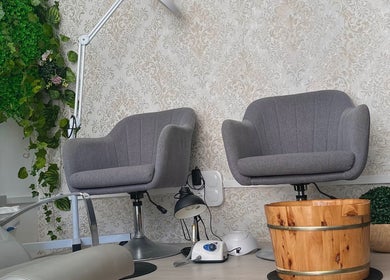 Interior acogedor de For Ever Beauty Center en Barcelona, Catalunya, ES, con cómodas sillas grises y decoración verde.