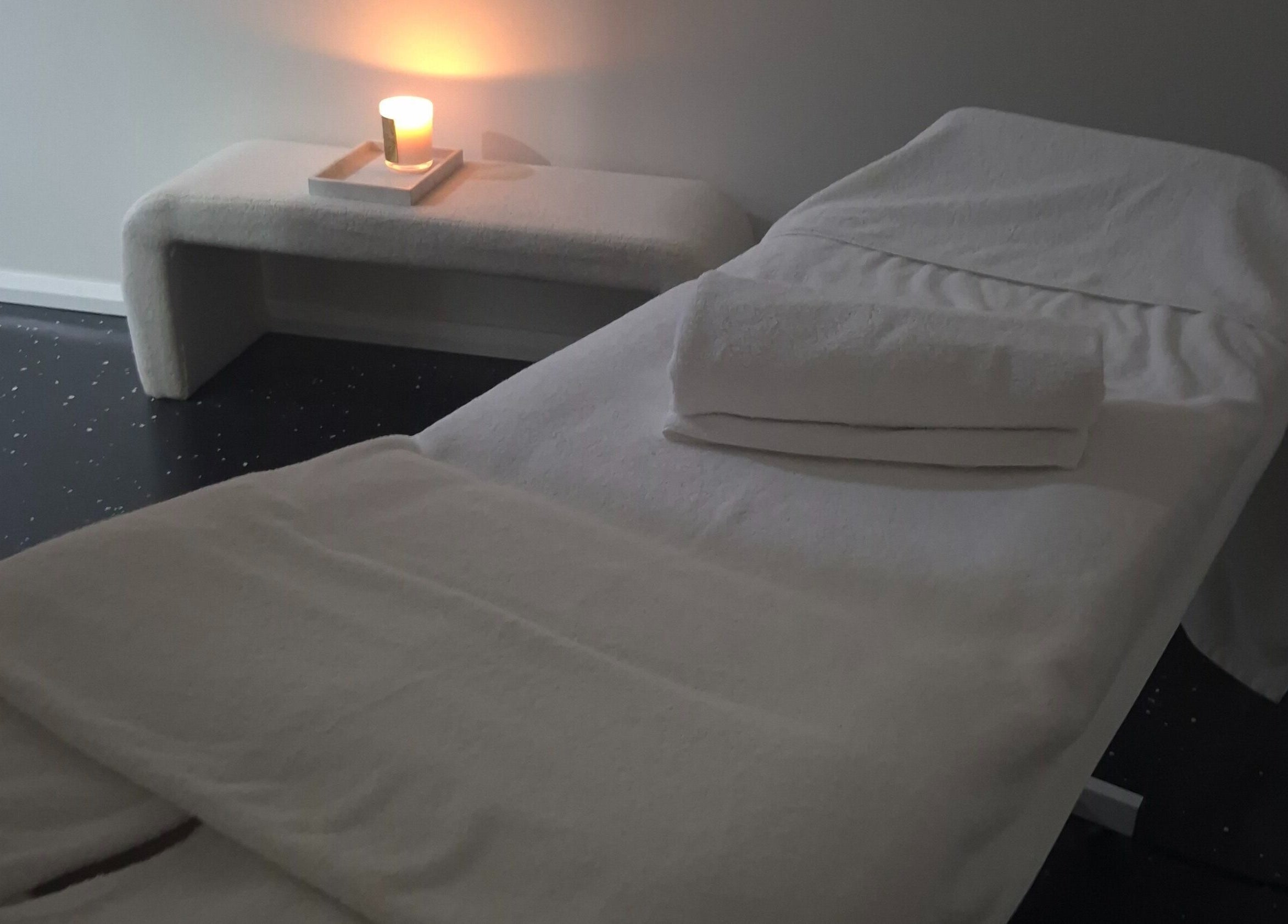 Tranquil massage room at Bare Bronze Skin Clinic, Strathdale, Victoria, AU, featuring candlelit ambiance.