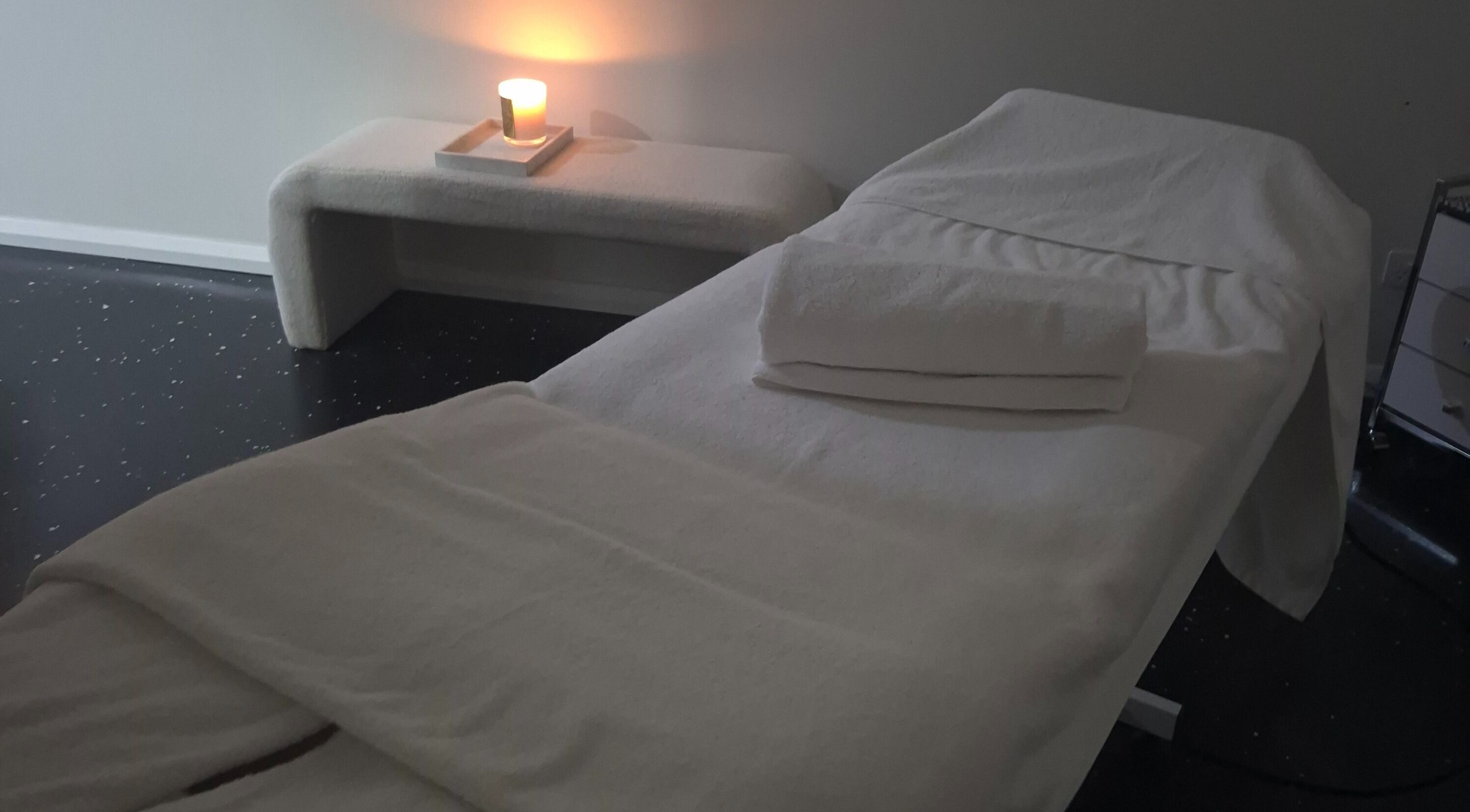 Tranquil massage room at Bare Bronze Skin Clinic, Strathdale, Victoria, AU, featuring candlelit ambiance.