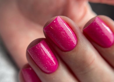 Vibrant pink nails with glitter at Auric Alchemy Nails, Northampton, England, GB.
