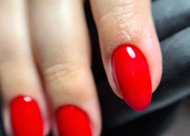 Close-up of vibrant red nails at Auric Alchemy Nails, Northampton, England, GB showcasing expert manicure.