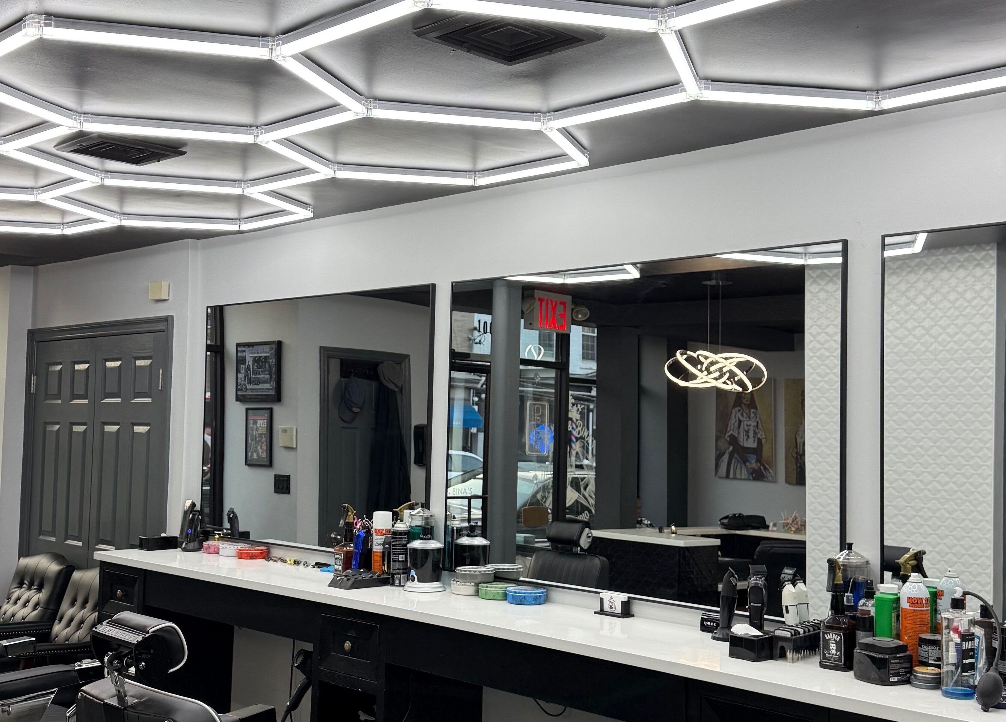 Modern interior of Benny & Bina’s salon, Dobbs Ferry, New York, US with sleek barber chairs and bright lighting.