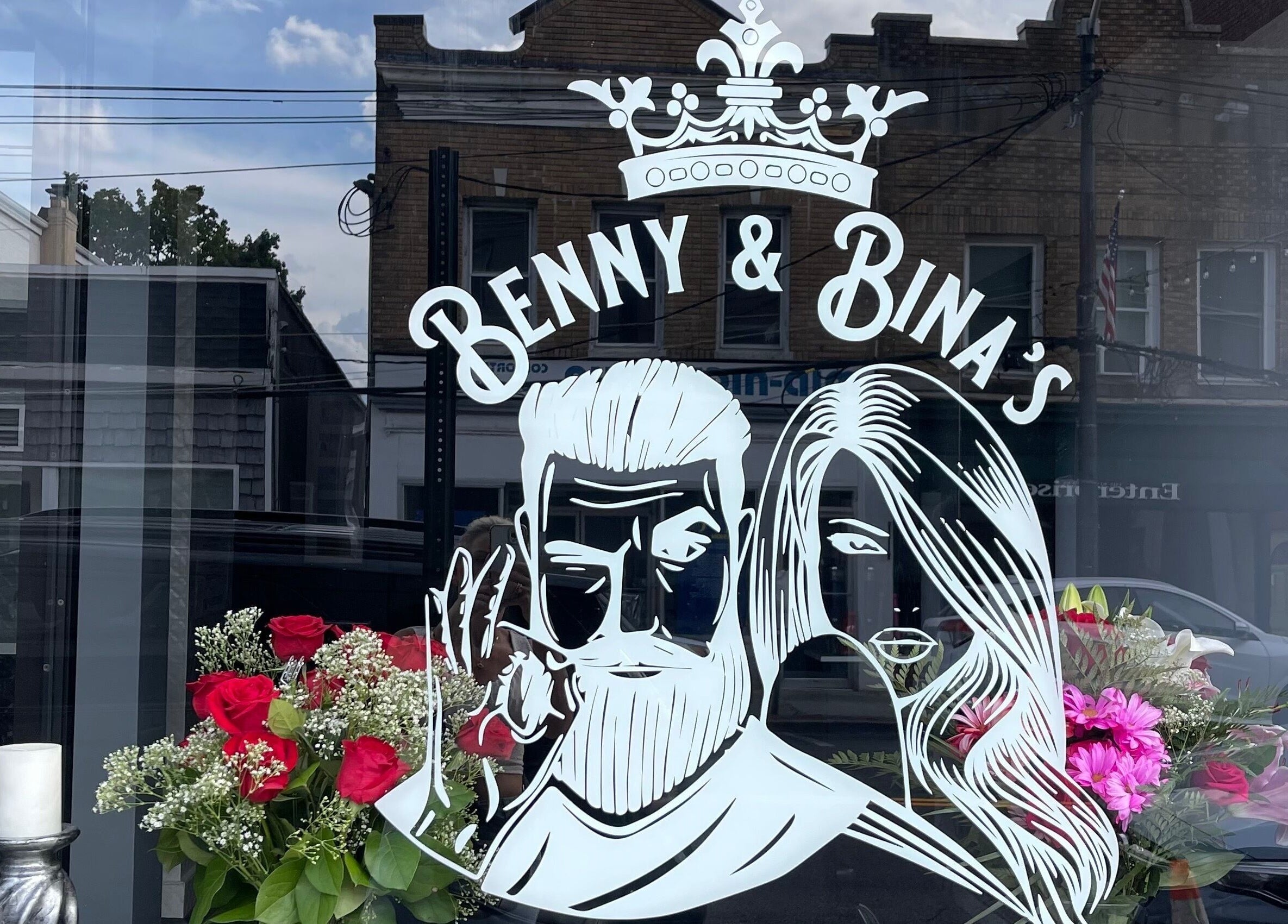 Benny & Bina’s storefront sign with floral display in Dobbs Ferry, New York, US.