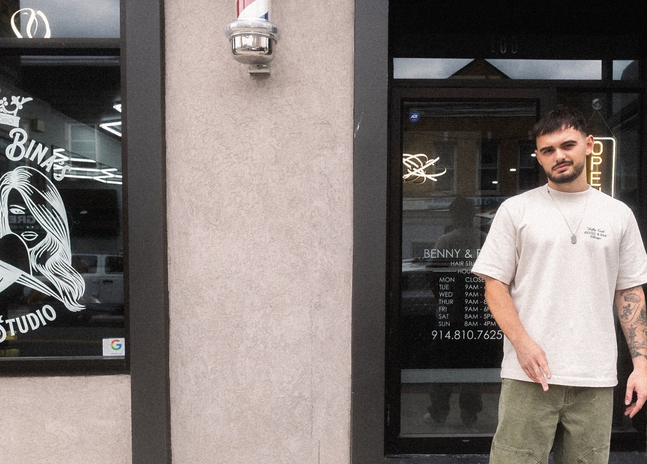 Exterior view of Benny & Bina’s Hair Studio in Dobbs Ferry, New York, US with a person standing outside.
