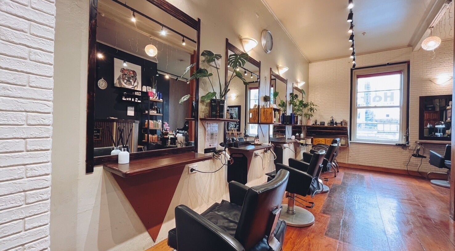 Stylish interior of Oasis Hair Dressing in Auckland, Auckland, NZ with elegant salon chairs and mirrors.