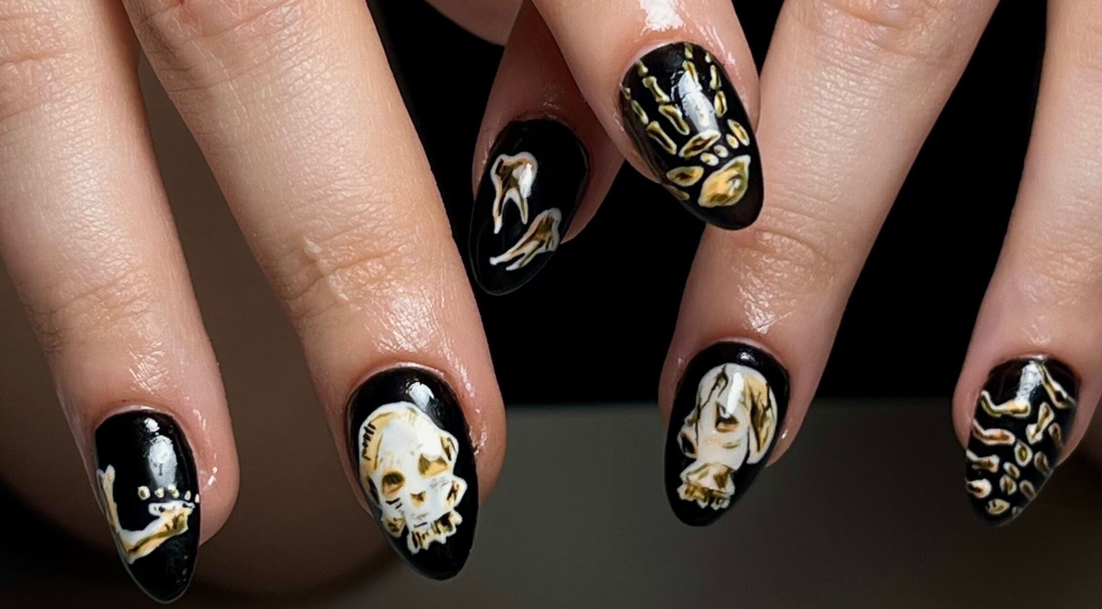Intricate skull nail art at laDiri Nails, București, București, RO, showcasing unique black and gold designs.