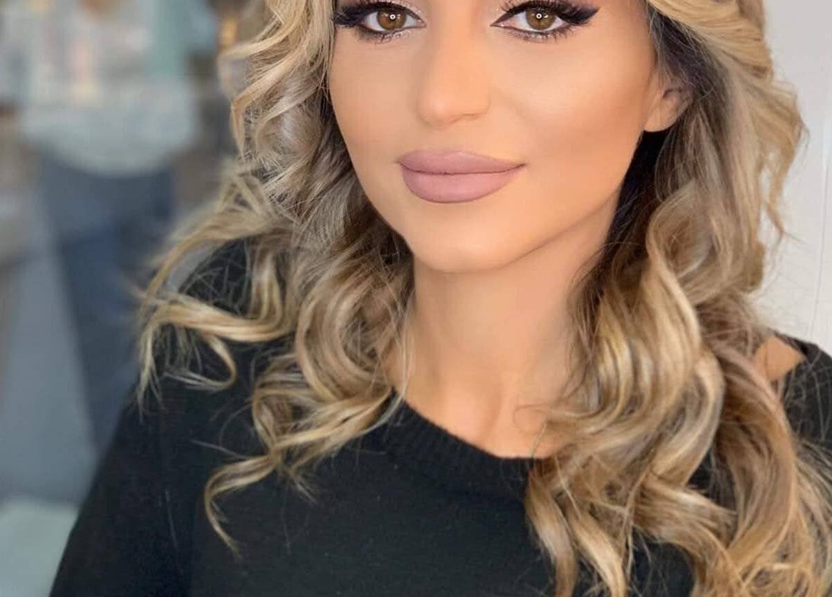 Vrouw met zachte krullen in Infinity salon, Kruisem, Vlaanderen, BE, straalt zelfvertrouwen uit.