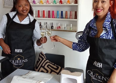 Team members at Queens Beauty Parlor in Sasolburg, Free State, ZA, toasting in a vibrant nail salon.