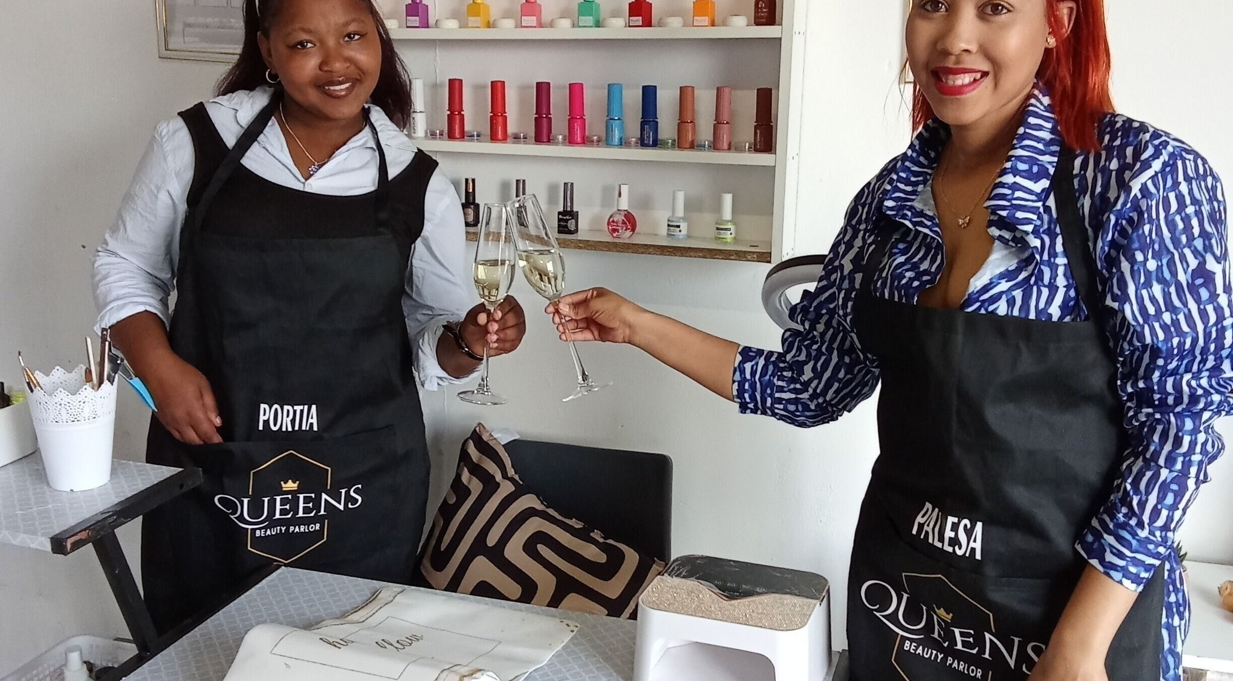 Team members at Queens Beauty Parlor in Sasolburg, Free State, ZA, toasting in a vibrant nail salon.