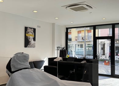 Interno di George The Barber a Crema, Lombardia, IT con un cliente in sedia e dettagli moderni.