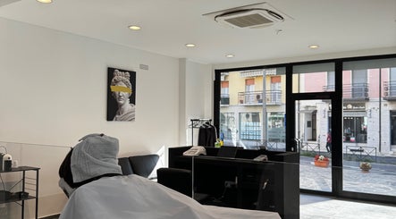 Interno di George The Barber a Crema, Lombardia, IT con un cliente in sedia e dettagli moderni.