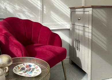 Elegant red velvet chair and side table at Sims Beauty, Stilton, England, GB. Perfect for relaxation.
