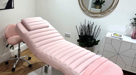 Relaxing treatment room at Micro Glow PMU, London, England, GB with a pink massage bed and elegant decor.