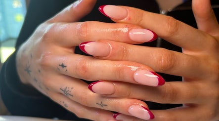 Elegant red-tipped manicure at Beautbynatz, Bathgate, Scotland, GB showcasing detailed nail artistry.