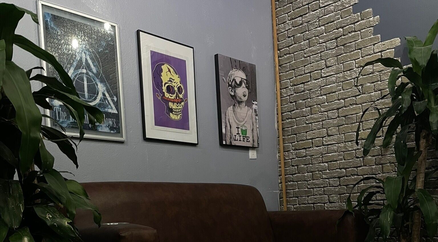 Decoración moderna en Barbería Men's Cave, El Pueblito, Querétaro, MX, con arte en la pared y plantas verdes.