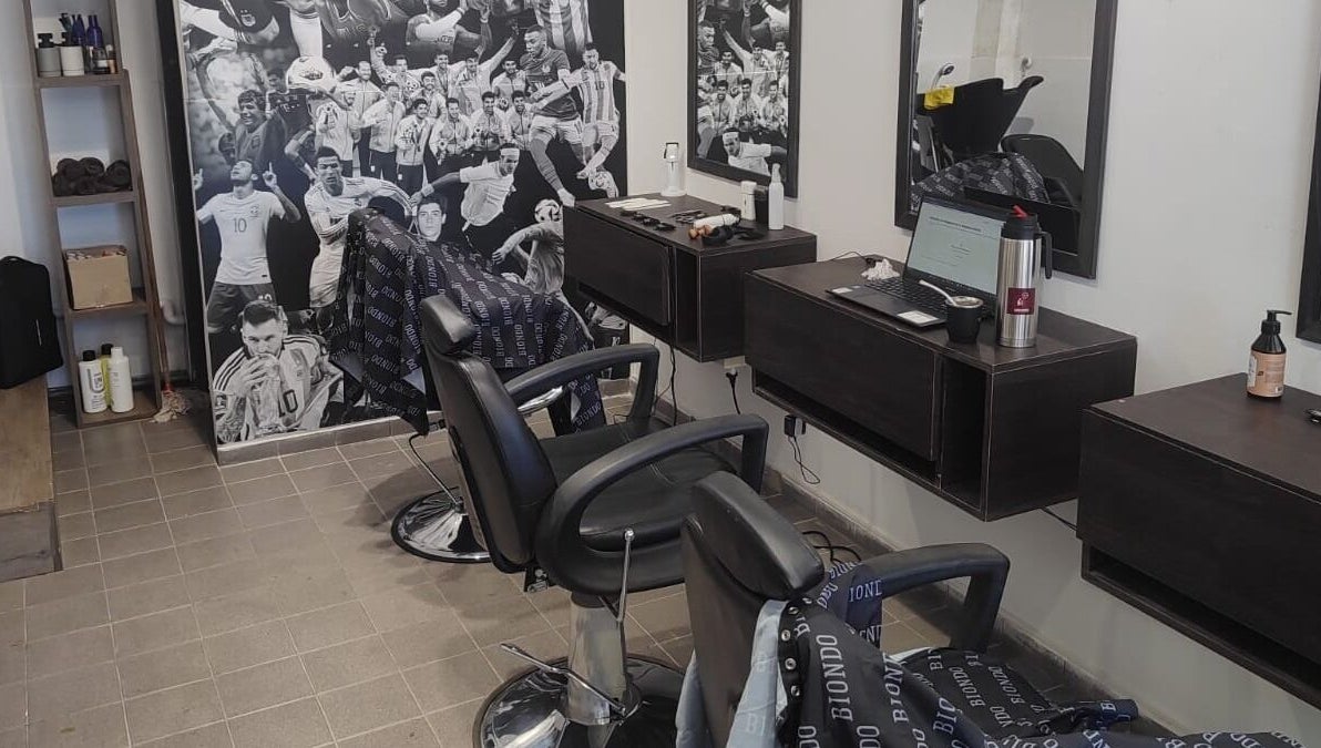 Interior moderno de la peluquería Biondo en San Juan, San Juan, AR, con sillas y decoraciones deportivas.