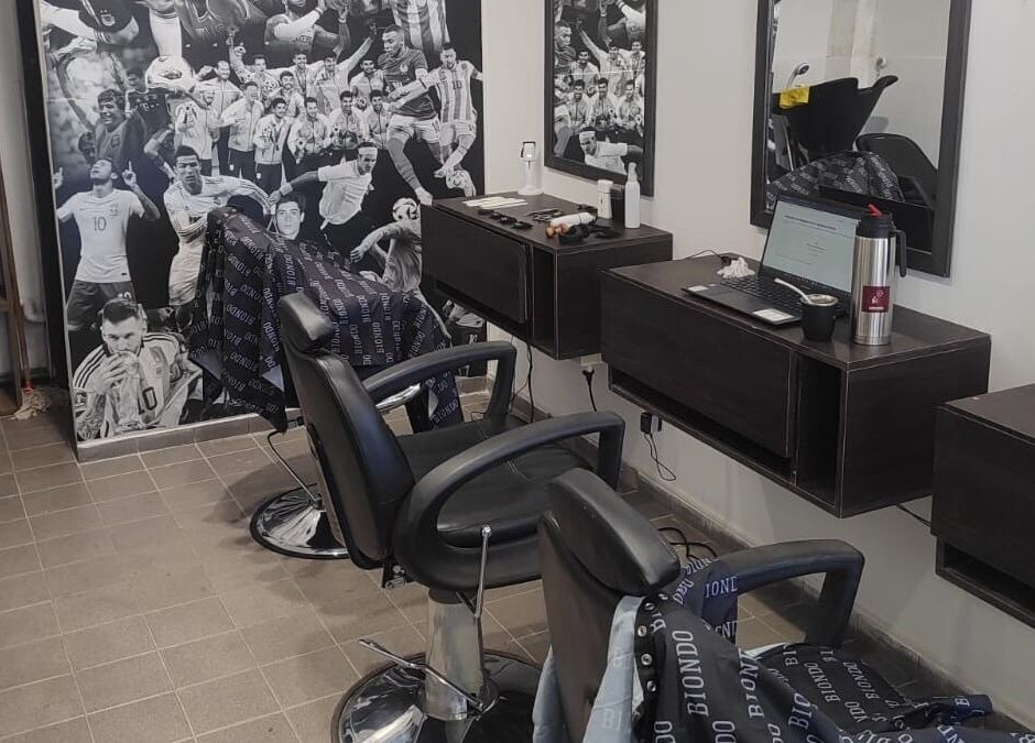 Interior moderno de la peluquería Biondo en San Juan, San Juan, AR, con sillas y decoraciones deportivas.