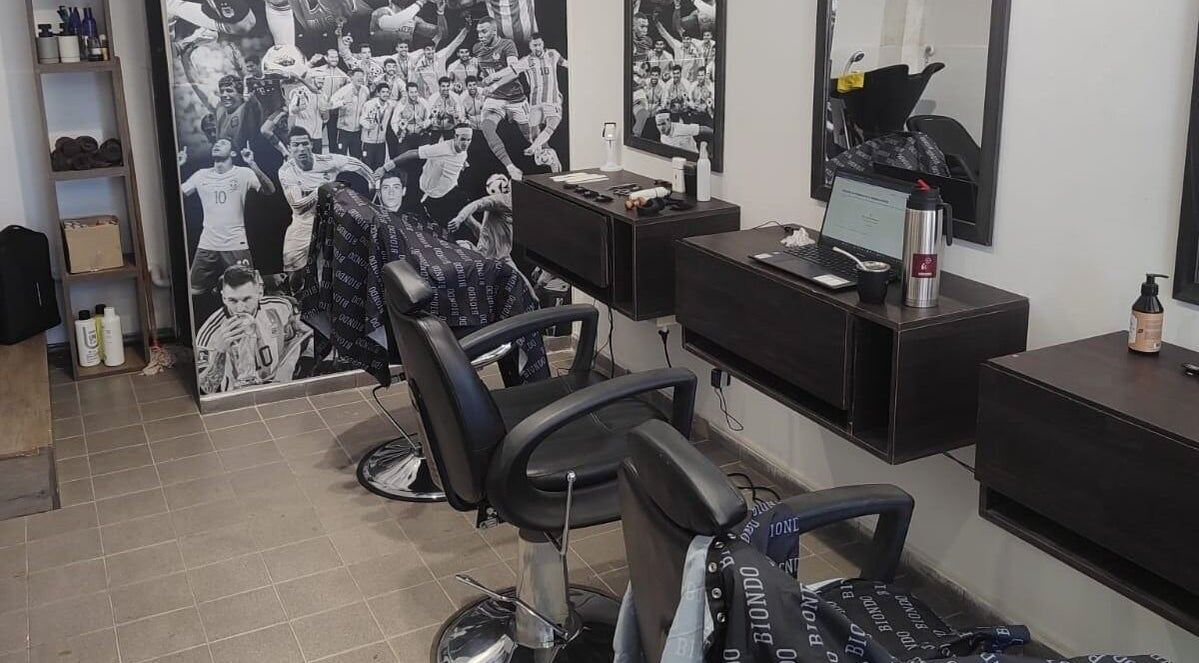 Interior moderno de la peluquería Biondo en San Juan, San Juan, AR, con sillas y decoraciones deportivas.