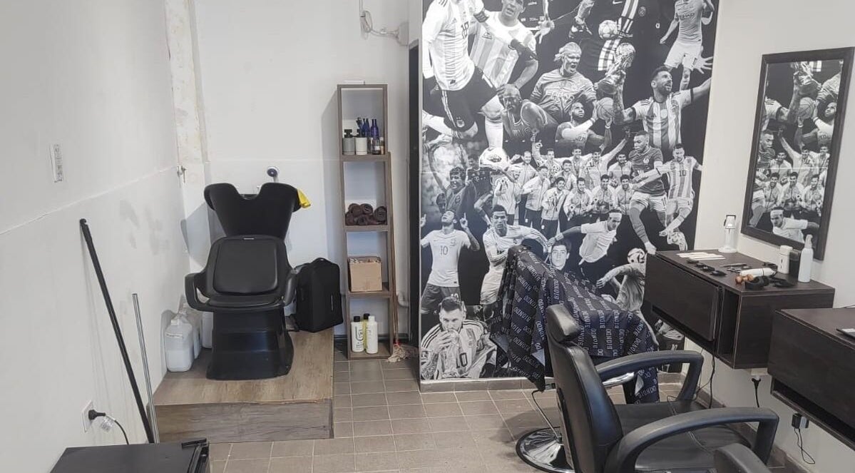 Interior del salón Biondo en San Juan, San Juan, AR, con silla de barbero y decoración de deportistas.