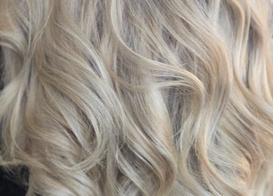 Blonde wavy hair styled at Dreamcuts and Styles, Fulshear, Texas, US, showcasing elegant curls.