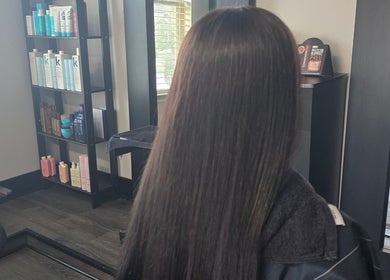 Long, straightened hair in Dreamcuts and Styles salon, Fulshear, Texas, US, with shelves of hair products.